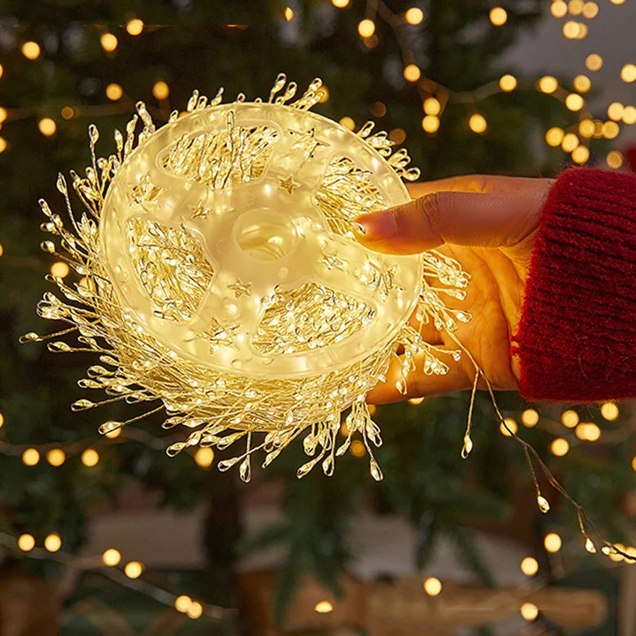 Warm white cluster lights held in hand in front of a Christmas tree