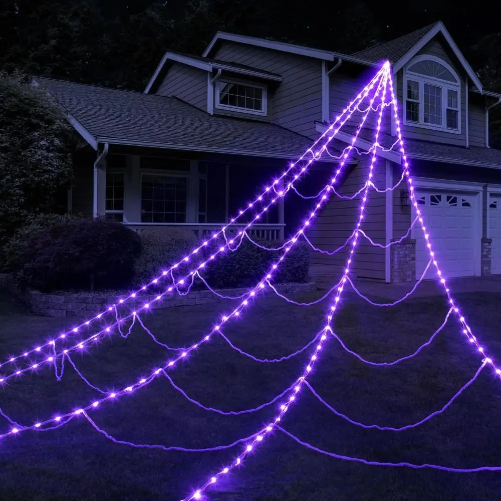 Light-up spider web on house front at night