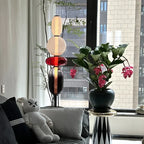 Opal coloured glass floor lamp in a bright living room by the window