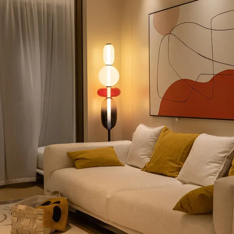 Opal stacked glass floor lamp glowing beside a sofa in a living room