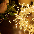 Warm white firecracker cluster lights draped with greenery