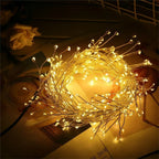Warm white firecracker cluster lights coiled on a table