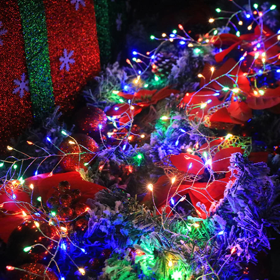 Multicolour firecracker cluster lights on a Christmas tree with red decorations