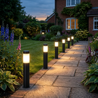 Black Arden solar bollard lights lining a paved UK garden path at dusk