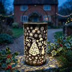 Solar Christmas garden lantern glowing on a UK cottage garden wall at night