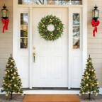 Pre-lit Christmas wreath on a white front door with festive decorations