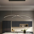 Matte black linear arc pendant light over a minimalist kitchen island with white marble and dark grey cabinetry