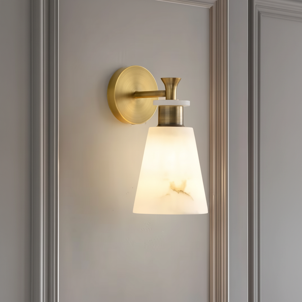 Marble wall lamp lit on a grey panelled wall, close view of the tapered stone shade