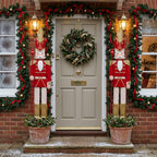 Red 6ft nutcracker decorations either side of a front door with Christmas garland