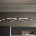 Close-up detail of matte black linear arc pendant light with warm white LED glow