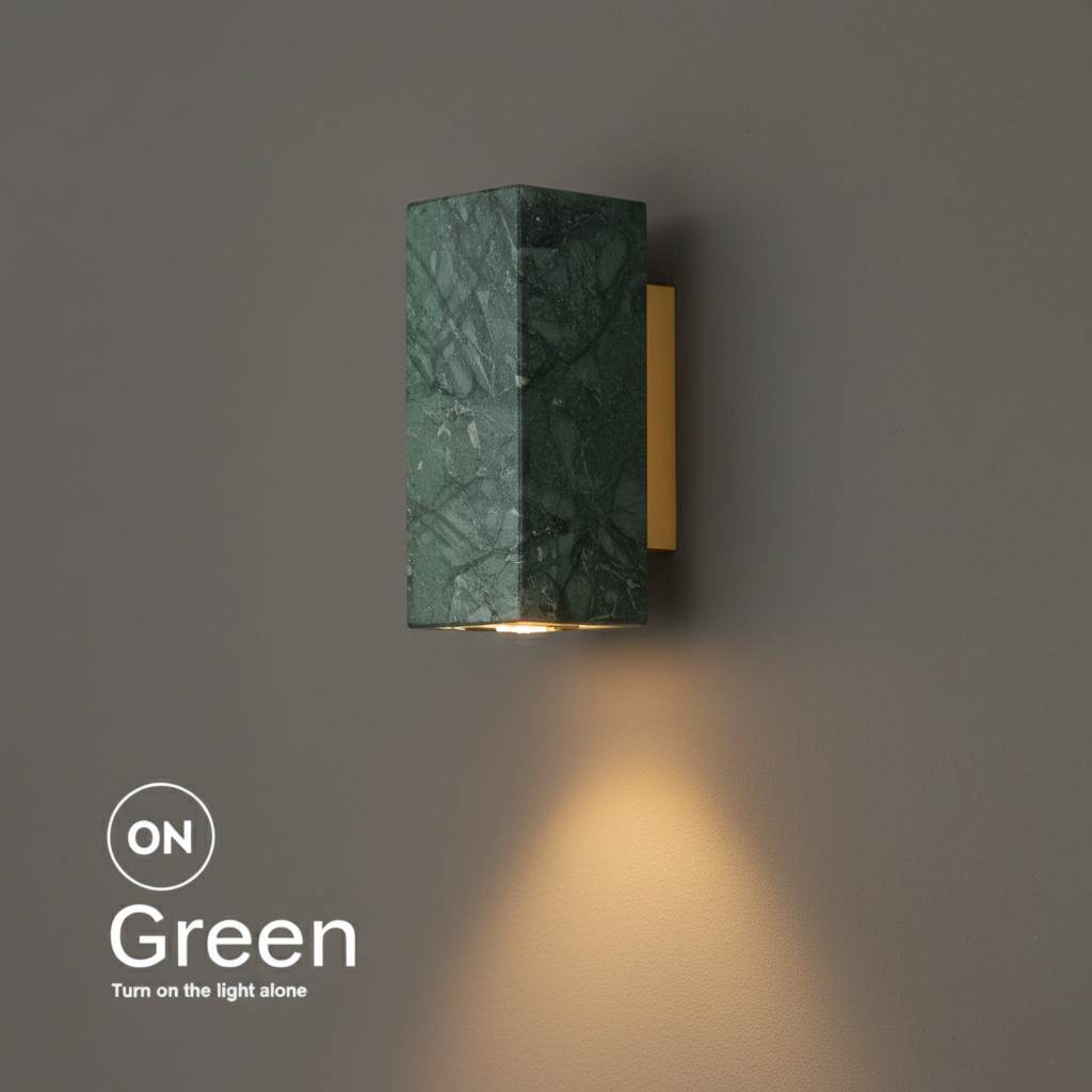 Marble bedside wall light, square green marble shade on a brass bracket, lit with a warm downward glow