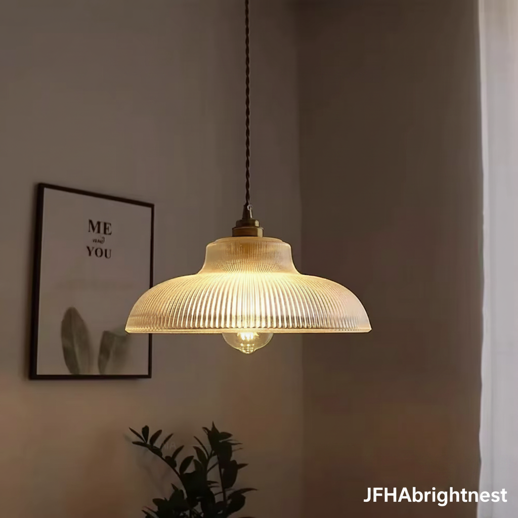 Clear ribbed glass pendant light lit with a warm bulb in a hallway