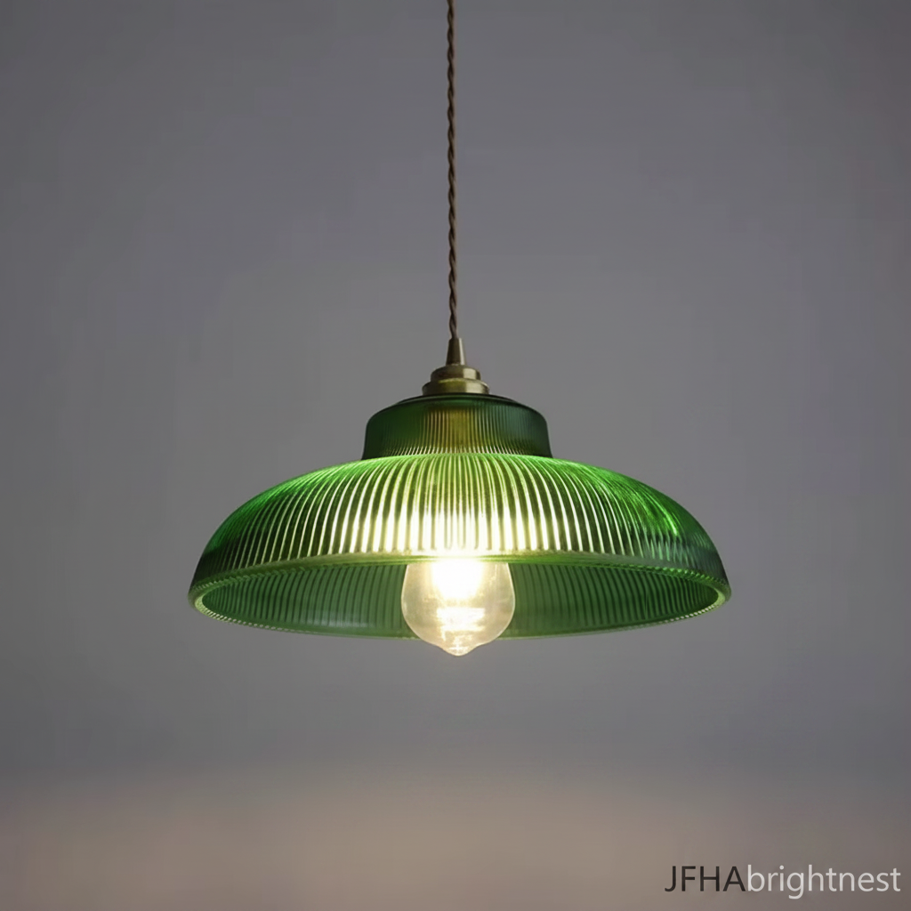 Green ribbed glass pendant light lit with a warm bulb, brass lamp holder and gold cable