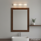 Warm white bathroom wall light above a wood-framed mirror and basin