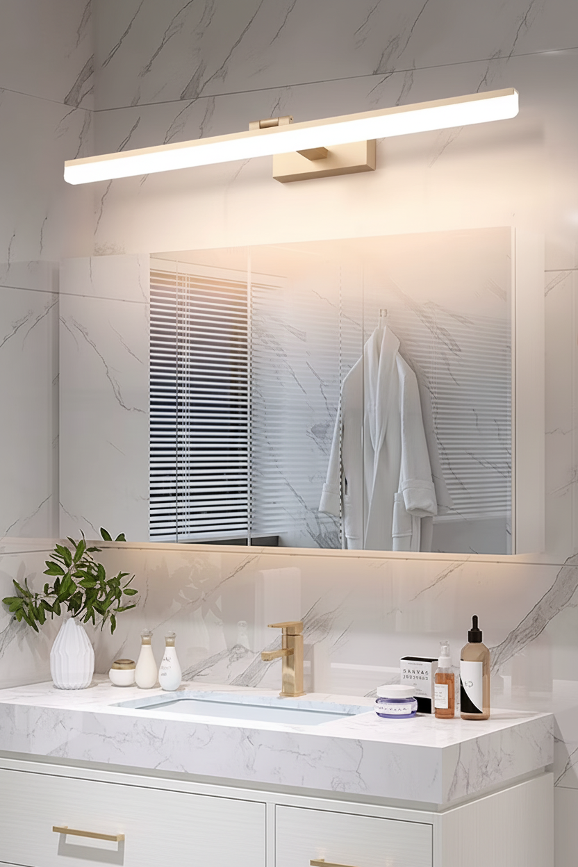 Gold LED mirror light above a mirror in a marble bathroom