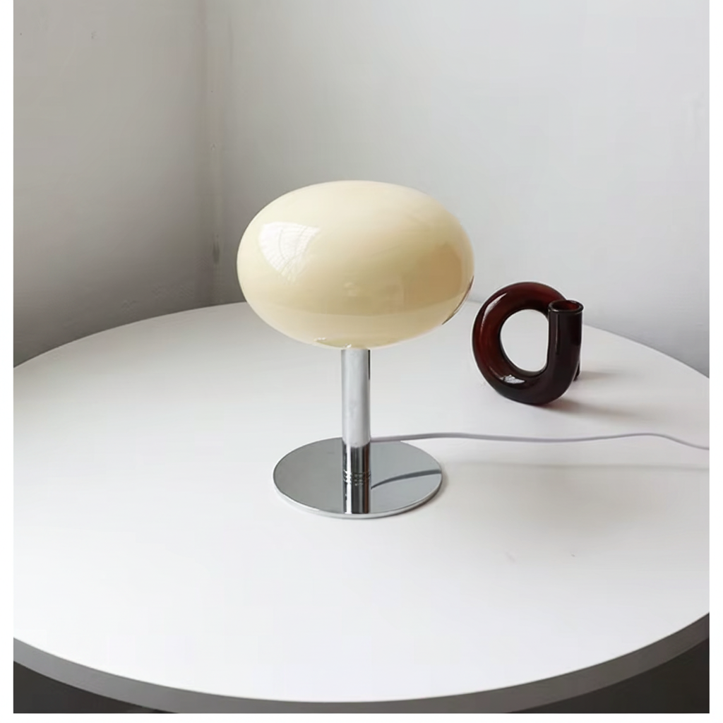 Cream dome macaron glass table lamp on a white table