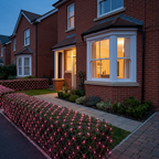 Pink LED net mesh fairy lights on a hedge outside a UK home