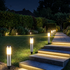 Silver solar bollard lights along stone garden steps and lawn at night