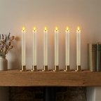 Six ivory candles on a UK cottage mantelpiece