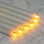 Square clone of six glowing ivory candles on marble