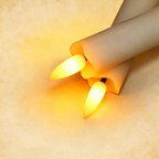 Square close-up of two glowing ivory flameless candles