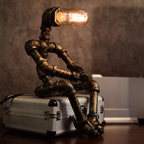 Square product image of the illuminated robot lamp seated on a silver case