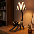 Cat floor lamp glowing warmly in the evening on a wooden sideboard