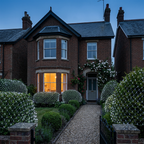 Cool white LED net mesh fairy lights on a hedge outside a UK home